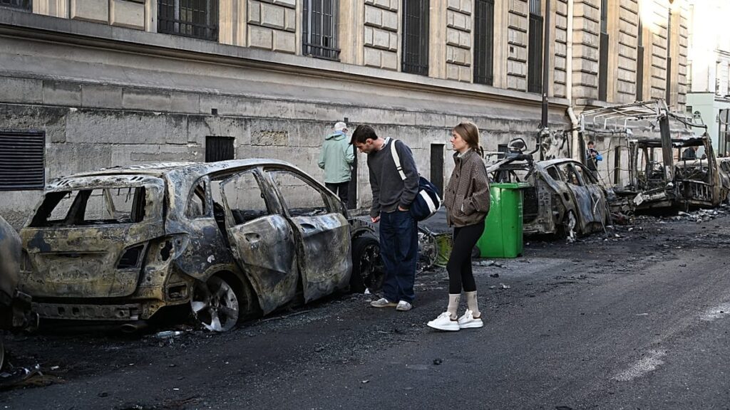 Francia: Macron rechaza la dimisión de su ministro del Interior y las bolsas abren en rojo tras los disturbios Autos calcinados en una calle cercana a la plaza de la República, en París, tras los disturbios del 17 de octubre