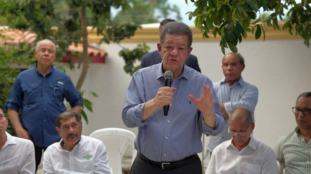 Leonel Fernández habla con un micrófono durante su encuentro con productores de arroz en Jima, La Vega