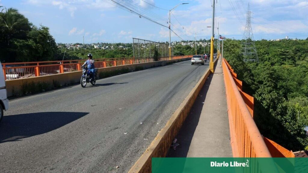 La Barquita, en tendencia: desde hoy a las 6:00 p. m. no pasan vehículos pesados por el puente Una motocicleta y un carro circulan por el puente de La Barquita, con barandas anaranjadas y vegetación a ambos lados