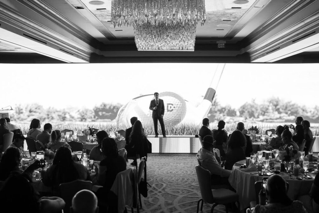 Houston, una tendencia impulsada: una ráfaga de cuentas casi nuevas aplaude en minutos el roadshow 124 de David Collado Un expositor habla desde el escenario ante agentes de viajes sentados en mesas durante el roadshow de promoción turística dominicana en Houston