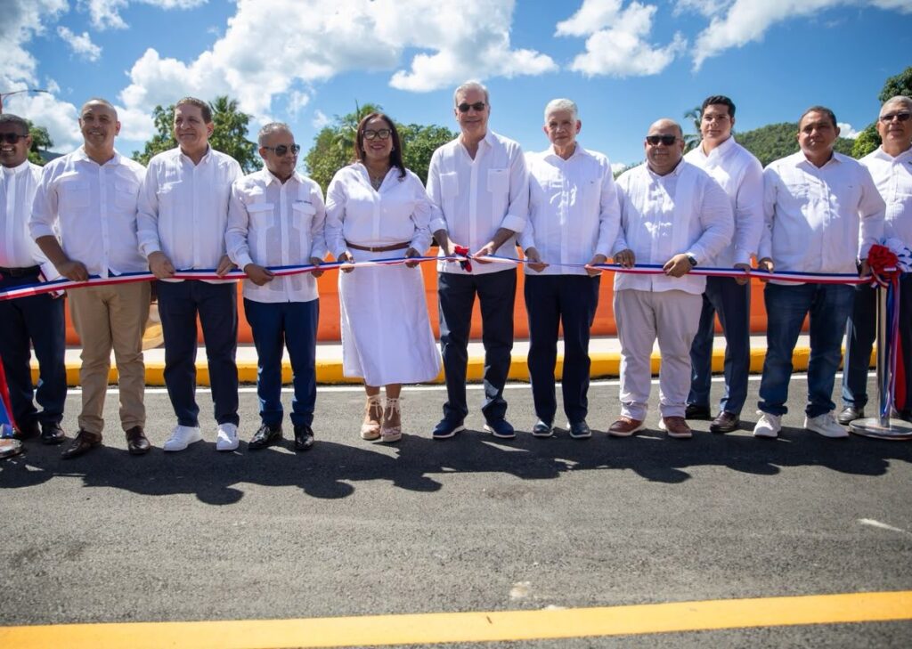 El presidente Luis Abinader, en el centro, sostiene junto a otras autoridades la cinta tricolor sobre el nuevo puente del río La Leonora, en Maimón, durante la inauguración